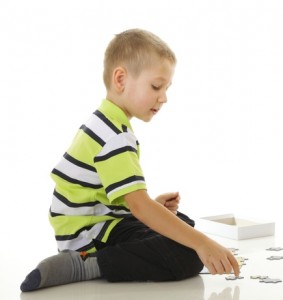 child boy playing puzzle isolated